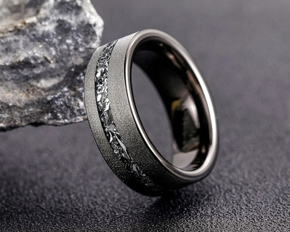 Cosmos ring with meteorite inlay on dark surface