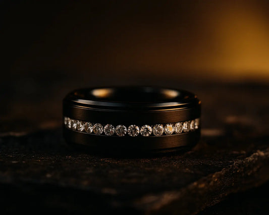 Black ring with embedded diamonds on a dark surface