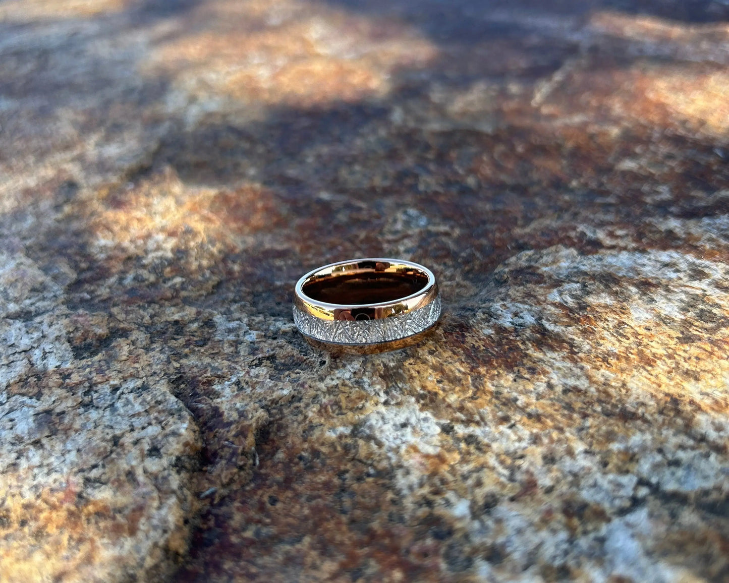 Rose gold ring with meteorite inlay on textured rock