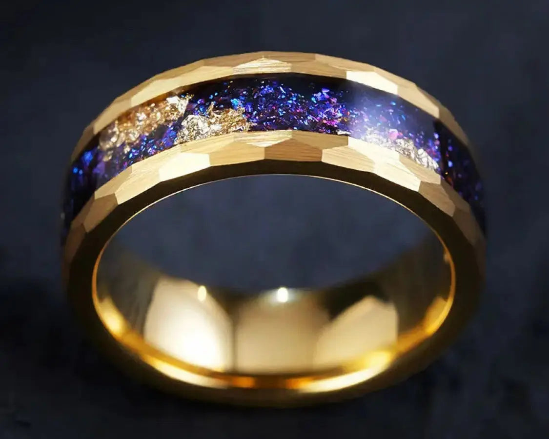 Gold ring with blue & gold stardust inlay on a dark surface