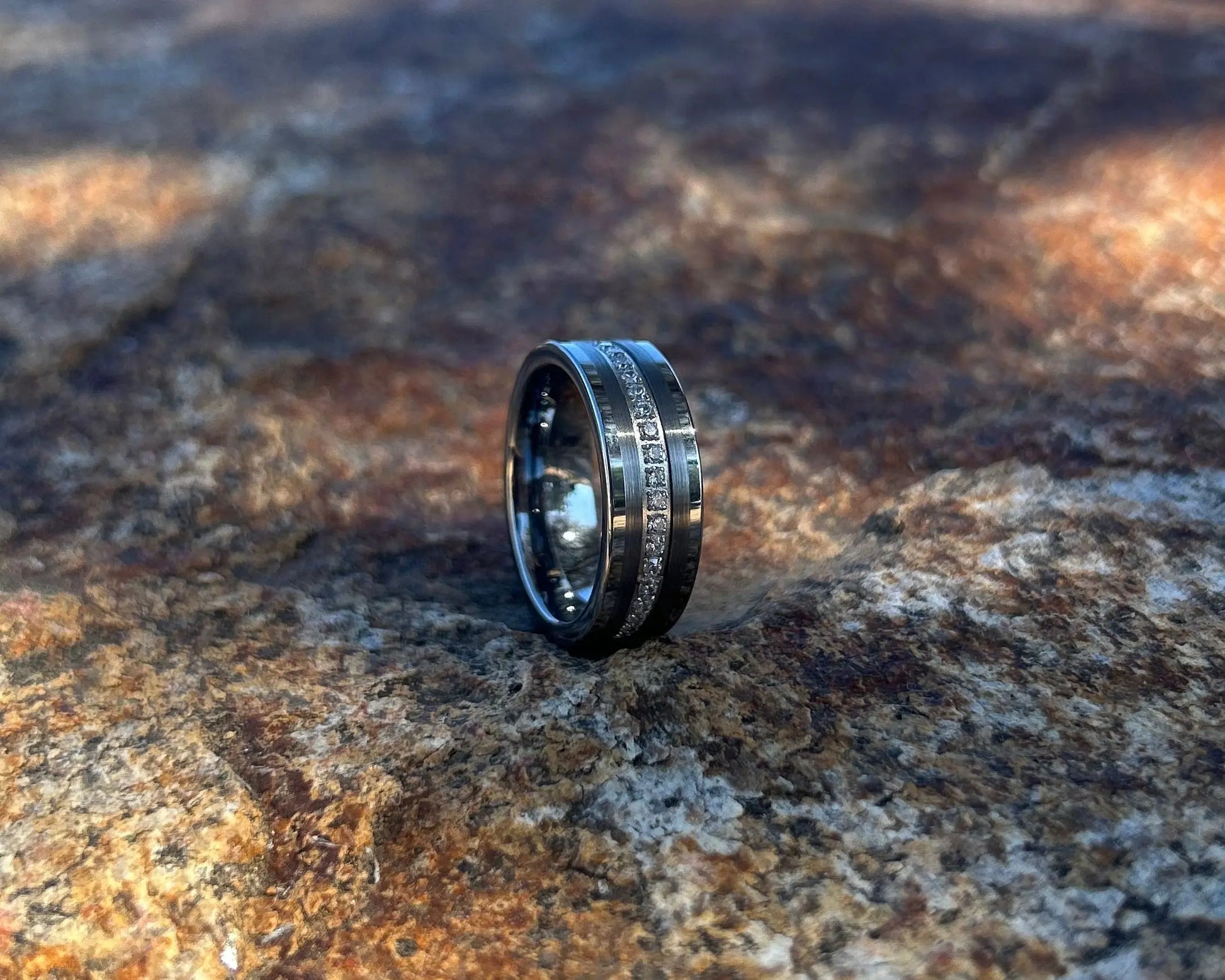 Silver ring on a textured stone surface with a blue sky background