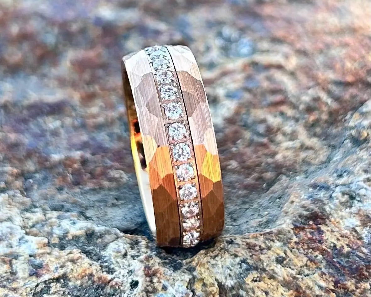 Gold ring with embedded diamonds on a textured stone surface