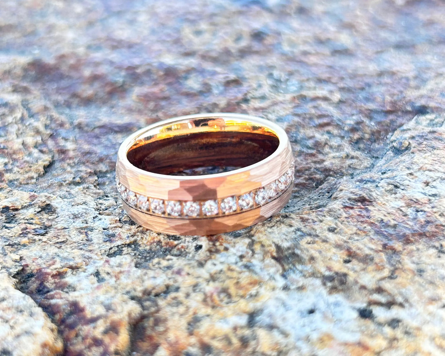 Gold ring with diamonds on a textured stone surface