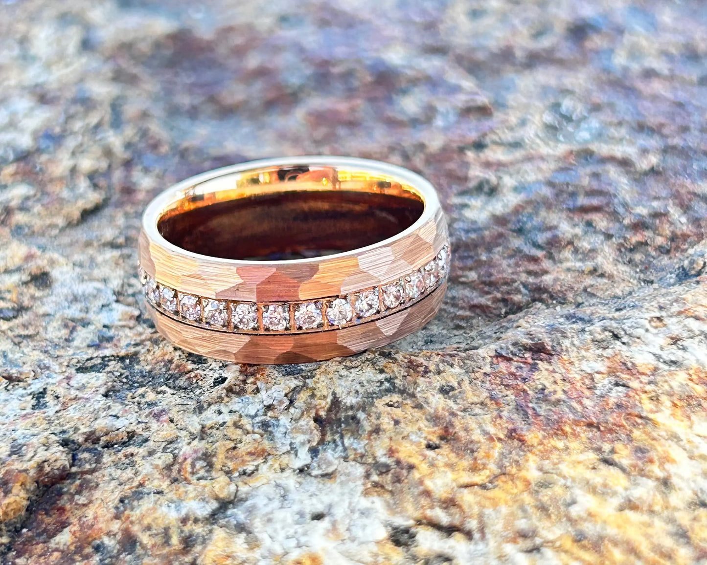 Gold ring with diamonds on a textured stone surface