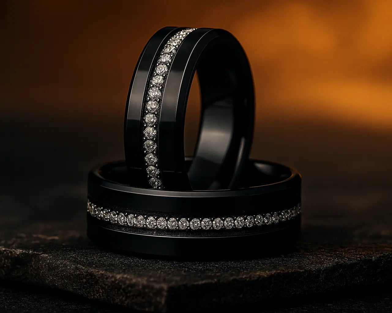 Two black rings with diamond accents on a dark background