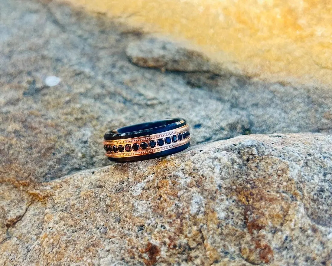 Black & gold ring with black CZ stones on a textured stone