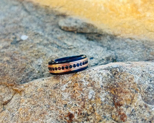 Black & gold ring with black CZ stones on a textured stone