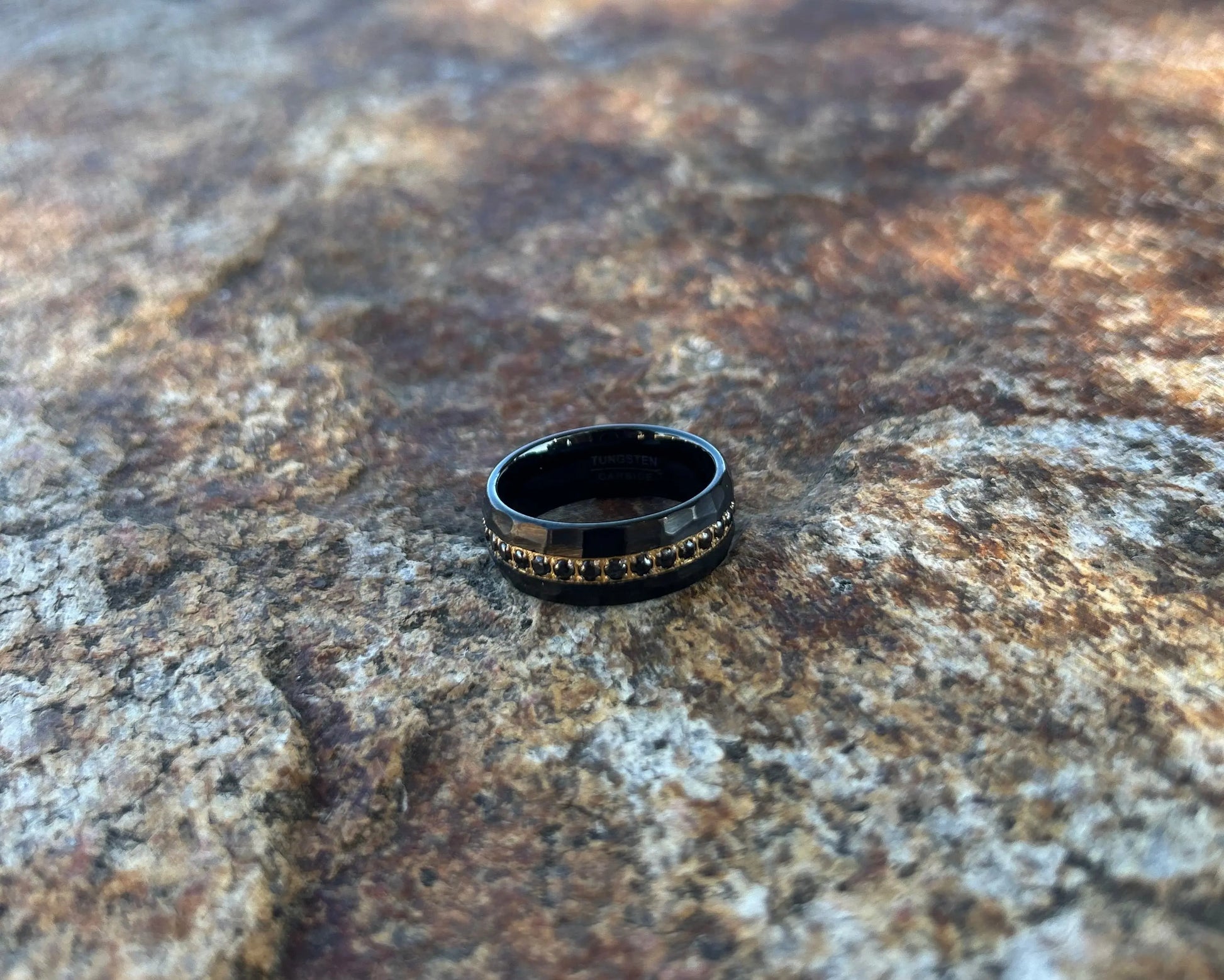 Black ring with gold accents around black CZ's on a textured stone