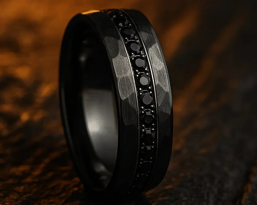 Black ring with embedded stones on a textured brown surface