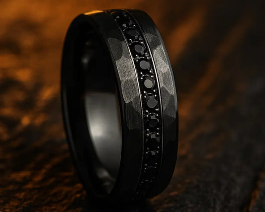 Black ring with embedded stones on a textured brown surface