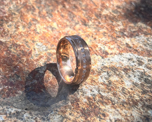 Gold ring with CZ band on a textured stone surface