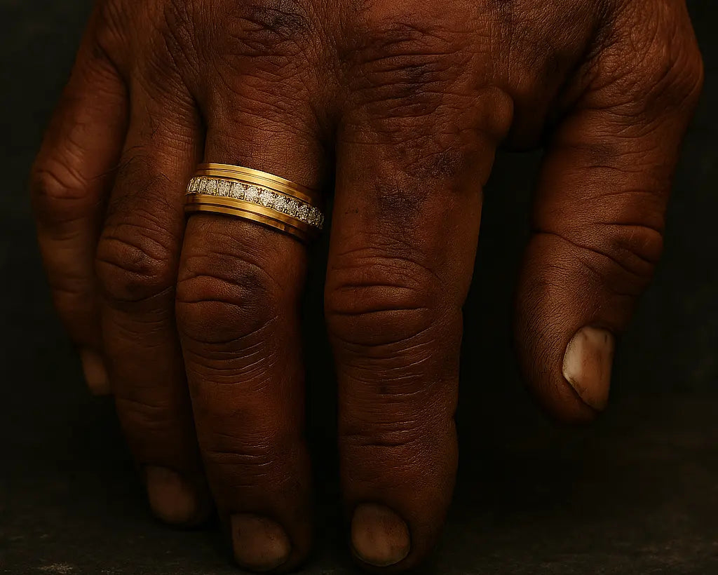 Close-up of a brown hand with a gold ring on a dark background