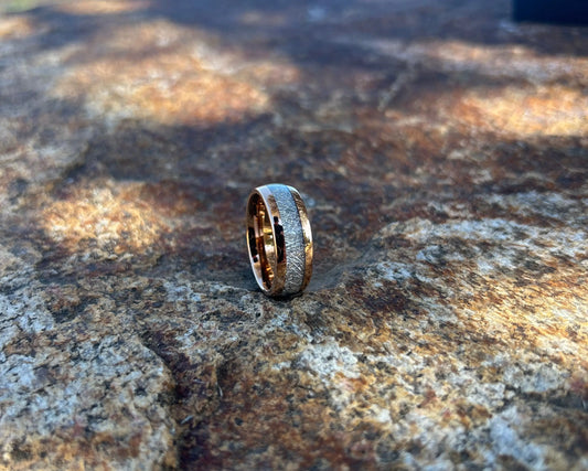 Rose gold ring with meteorite inlay on textured rock